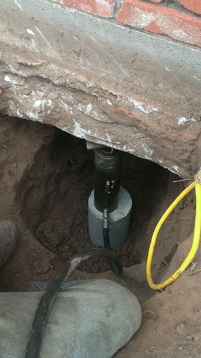 This image shows a hydraulic jack that we use to lift our structures and repair foundations. Once installed, these jacks are permanently left in place to provide permanent support and maintenance if necessary. 
