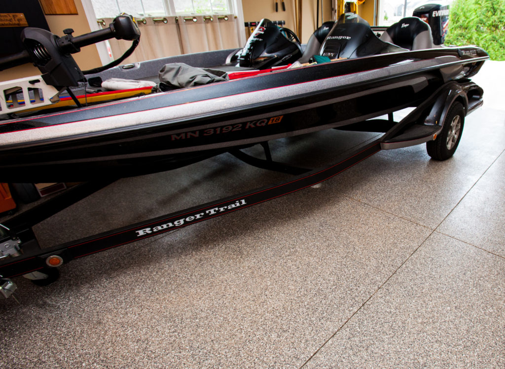 Our Industrial Flooring Products provide the perfect solution for a wide range of home applications. This image shows a boat trailer parked on our Vinyl Chip System system installed inside of a garage. These floors are tough and spill resistant, abrasion resistant and backed with a 15-year manufacturer warranty!