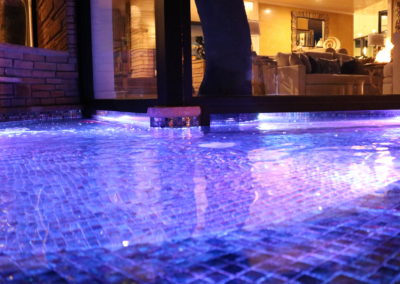 Our House on a Hill project includes a gorgeous display of LED lit water features paired elegantly with fire pit lighting. This is the completion of a backyard renovation project that lasted 6 months from start to finish. This image shows our LED lit water fountain on our raised deck.