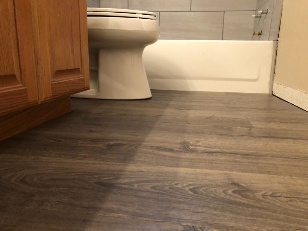 Here is a great snap shot of our renovated bathroom floor. Here you can see our gorgeous gray hardwood looking tile. Tile is great due to its waterproofing features!